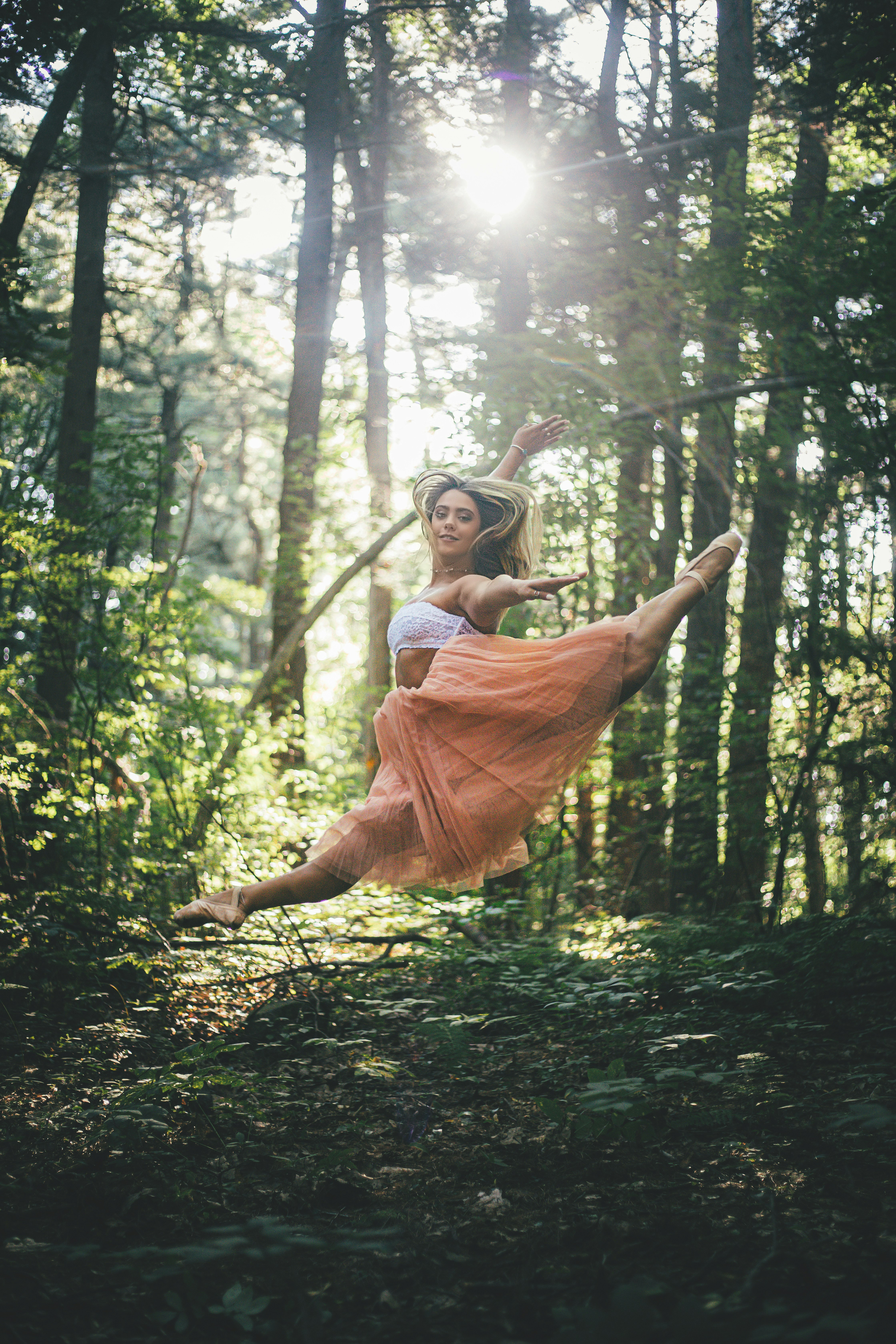 woman jumping surrounded by trees